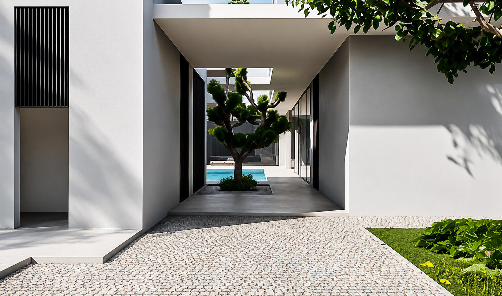 Covered entrance passage with a sculptural courtyard tree